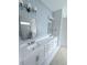 Stylish bathroom with blue wood paneling, dual sinks, and mirrors with modern light fixtures at 2790 Burden Creek Rd, Johns Island, SC 29455