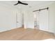 Bright bedroom featuring hardwood floors and sliding barn door leading to bathroom at 2790 Burden Creek Rd, Johns Island, SC 29455