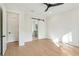 Bright bedroom featuring hardwood floors and sliding barn door leading to bathroom at 2790 Burden Creek Rd, Johns Island, SC 29455