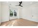 Sunlit bedroom with hardwood floors, a modern ceiling fan, and a large window overlooking greenery at 2790 Burden Creek Rd, Johns Island, SC 29455