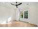 Sunlit bedroom with hardwood floors, a modern ceiling fan, and a large window overlooking greenery at 2790 Burden Creek Rd, Johns Island, SC 29455