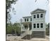 A two-story home on pilings with pale siding and a white porch railing at 2790 Burden Creek Rd, Johns Island, SC 29455