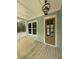 Front porch of a pale-sided home featuring a wood floor, a front door and railings at 2790 Burden Creek Rd, Johns Island, SC 29455