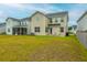 Wide backyard featuring a lush green lawn, patio, and a charming view of the home's exterior at 297 Red Leaf Blvd, Moncks Corner, SC 29461