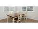 Charming dining room with a wooden table, white chairs, and natural light from the windows at 297 Red Leaf Blvd, Moncks Corner, SC 29461