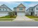 Charming two-story home with a well-manicured lawn and a wide driveway leading to an attached two-car garage at 297 Red Leaf Blvd, Moncks Corner, SC 29461