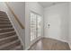 Bright foyer featuring hardwood floors, stairs to the upper level, and glass French doors to another room at 341 Witch Hazel St, Summerville, SC 29486