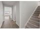 Hallway with hardwood floors that leads to a stairway and an open-concept living area with windows at 341 Witch Hazel St, Summerville, SC 29486