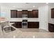 Well-equipped kitchen featuring granite countertops, stainless steel appliances, and dark wood cabinets at 341 Witch Hazel St, Summerville, SC 29486