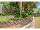 Backyard landscaping features a tiered stone retaining wall with green foliage and mulch at 3632 Locklear Ln, Mount Pleasant, SC 29466