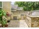 The outdoor kitchen has stainless steel appliances and a stone backsplash on a stone paver patio at 3632 Locklear Ln, Mount Pleasant, SC 29466