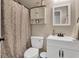 Modern bathroom includes a white vanity with dark hardware, mirror, toilet and shower with curtain at 406 Carolina Cir, Ladson, SC 29456