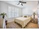 A cozy bedroom with wood floors features a large window with plantation shutters and a quaint side table at 413 Eagleview Dr, Moncks Corner, SC 29461