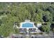 Aerial view of the rectangular pool and pergola area with lounge chairs and cabanas surrounded by trees and parking at 4227 Sawgrass Dr, North Charleston, SC 29420