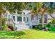 Inviting back deck with stairs, a screened porch, well maintained lawn and mature landscaping for outdoor enjoyment at 4227 Sawgrass Dr, North Charleston, SC 29420