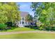 Charming backyard with professionally landscaped yard, stairs leading to a screened in porch and mature trees at 4227 Sawgrass Dr, North Charleston, SC 29420