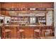 Well-stocked bar area with wood bar, seating, and liquor bottles, creating a perfect space for socializing at 4227 Sawgrass Dr, North Charleston, SC 29420