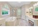 This spacious bathroom features a separate glass shower, soaking tub, vanity, and plenty of natural light at 4227 Sawgrass Dr, North Charleston, SC 29420