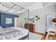 Bedroom featuring a canopy bed, tray ceiling, hardwood floors, and white paneled walls at 4227 Sawgrass Dr, North Charleston, SC 29420