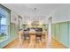 Traditional dining room featuring wood floors, wainscoting, a modern light fixture, and plenty of natural light at 4227 Sawgrass Dr, North Charleston, SC 29420