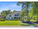 Charming two-story home with lush landscaping, manicured yard, and established trees at 4227 Sawgrass Dr, North Charleston, SC 29420