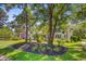 Lush front yard with a two-story home tucked behind mature trees at 4227 Sawgrass Dr, North Charleston, SC 29420