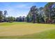 Picturesque golf course featuring manicured greens and towering pine trees on a sunny day at 4227 Sawgrass Dr, North Charleston, SC 29420