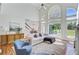 Sun-filled living room boasts hardwood floors, a fireplace, a large sofa, and a view to the backyard at 4227 Sawgrass Dr, North Charleston, SC 29420