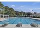 Outdoor swimming pool with diving blocks and lounge chairs surrounded by trees and flags at 4227 Sawgrass Dr, North Charleston, SC 29420