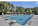 Outdoor swimming pool with diving blocks and lounge chairs surrounded by trees and flags at 4227 Sawgrass Dr, North Charleston, SC 29420