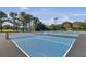 Multiple blue tennis courts with black netting and light posts surrounded by mature trees at 4227 Sawgrass Dr, North Charleston, SC 29420