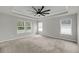 Spacious bedroom featuring a modern ceiling fan, tray ceiling, and natural light from multiple windows at 4308 Cotton Flt Rd, Summerville, SC 29485