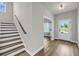 Inviting foyer with wood-look floors, staircase, and natural light streaming through the front door at 4308 Cotton Flt Rd, Summerville, SC 29485