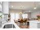 Open-concept dining area with modern chandelier, flowing into a comfortable living room and kitchen at 513 Donnas View Way, Summerville, SC 29486