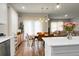 Bright dining room with modern light fixture, wood floors, and view into the living room at 513 Donnas View Way, Summerville, SC 29486