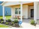 Inviting front porch featuring stylish seating, decorative plants, ADT security, and a freshly painted front door at 513 Donnas View Way, Summerville, SC 29486