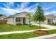 Charming single-story home with a well-manicured lawn and front porch seating, framed by mature trees and greenery at 513 Donnas View Way, Summerville, SC 29486