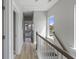 Upstairs hallway with wood floors, natural light, and white wood railing staircase at 515 Ivy Green Ln, Summerville, SC 29486