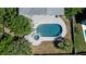 Aerial view of pool and patio with an outdoor umbrella, surrounded by palm trees and green grass at 764 Post Oak Dr, Mount Pleasant, SC 29464