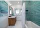 Bright bathroom featuring a wood vanity, bathtub with teal tile surround and a window at 764 Post Oak Dr, Mount Pleasant, SC 29464
