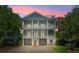 Exterior view of a three-story home with balconies, a driveway, well-manicured lawn, and mature trees at 764 Post Oak Dr, Mount Pleasant, SC 29464