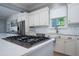 Close-up of a kitchen cooktop with white cabinets and a subway tile backsplash at 764 Post Oak Dr, Mount Pleasant, SC 29464