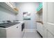 Well-lit laundry room featuring modern washer and dryer, storage shelves, and decorative art at 764 Post Oak Dr, Mount Pleasant, SC 29464