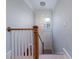 Bright staircase with modern light fixture and white and wood banister at 764 Post Oak Dr, Mount Pleasant, SC 29464