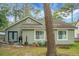 A home backyard with a charming patio space, lush greenery, and mature trees that provide ample shade at 7886 Racquet Rd, North Charleston, SC 29418