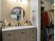Stylish bathroom featuring sleek vanity with round mirror and walk-in closet with ample storage space at 7886 Racquet Rd, North Charleston, SC 29418