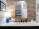 Well-lit bathroom with modern sink, vanity, and brick accent wall creating a charming ambiance at 7886 Racquet Rd, North Charleston, SC 29418