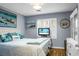 Comfortable bedroom with serene decor, plantation shutters, and a TV, perfect for relaxation at 7886 Racquet Rd, North Charleston, SC 29418