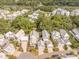 Stunning aerial view of a neighborhood with charming homes, lush trees, and a tranquil lake at 7935 Flagship Ln, Johns Island, SC 29455