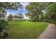 Expansive backyard featuring green lawn and pathway to the lovely white home at 7935 Flagship Ln, Johns Island, SC 29455